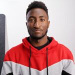 Marques Brownlee portrait photo in a red and grey sweatshirt.