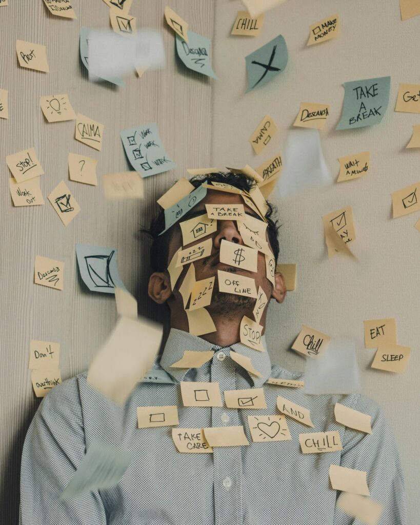 Man laying on the ground with post-it notes over his face and surrounding him.
